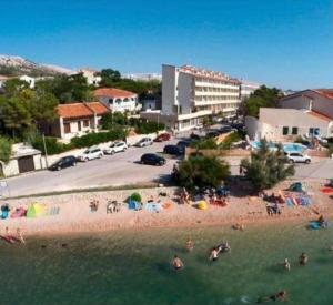 a group of people in the water at a beach at Apartment Murvica in Pag