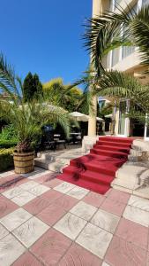 un camino de moqueta roja frente a un edificio en Хотел БУТИК ИМПЕРИАЛ, en Primorsko