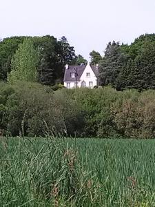 uma casa branca no meio de um campo em Chambres d'hôtes Saint Quinidic em Meros