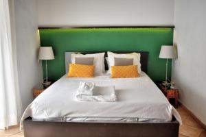 a bedroom with a large bed with a green headboard at Apartamentos Las Naranjas in Jerez de la Frontera