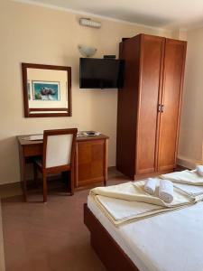 a hotel room with a bed and a desk and a chair at Apartments Villa Sveti Nikola in Budva