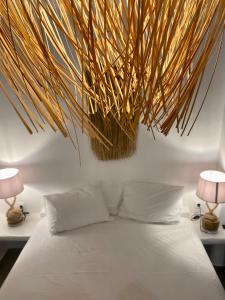 a bedroom with a white bed with two lamps at Iakovos' Luxury House in Tinos Town