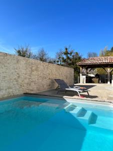 a swimming pool with a chair and a patio at La Girarde in Saint-Quentin-de-Caplong