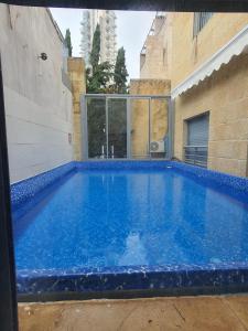 a large blue swimming pool in a building at Holyland Apartments in Jerusalem