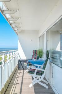 un balcón con sillas y mesas en un crucero en Nordseeblick Nordseeblick 111, en Norderney