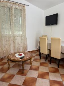 a living room with a table and chairs and a tv at Apartments Villa Sveti Nikola in Budva