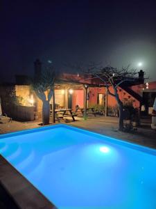 a blue swimming pool in front of a house at night at Villa los gavilanes in Santa Cruz de Tenerife +3 photos
