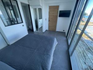 ein Schlafzimmer mit einem Bett in einem Zimmer mit Fenstern in der Unterkunft maison de bord de mer cap corse in Santa-Maria-di-Lota