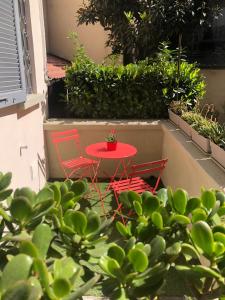 una mesa roja y sillas en un patio con plantas en FLAT66 en Milán