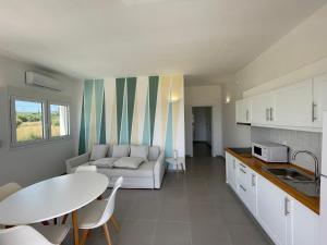een keuken en een woonkamer met een bank en een tafel bij Greek Dream Residence in Áyios Andréas Messinias