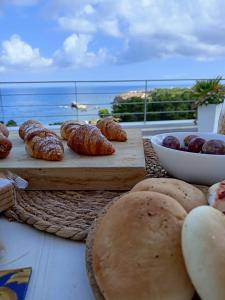 - une table avec du pain et des viennoiseries et une vue sur l'océan dans l'établissement Zabbàra B&B, à Terrasini