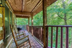 a porch of a cabin with two chairs on it at Bear Hug Too Cabin in Line Spring