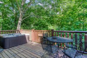 a patio with a table and chairs on a wooden deck at Bear Hug Too Cabin in Line Spring