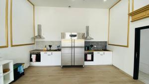 a kitchen with white cabinets and a stainless steel refrigerator at BED Cauchy in Namur