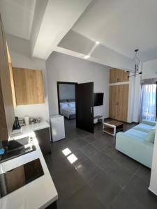 cocina y sala de estar con sofá azul en MEDORA By the Sea Near Airport, en Artemida