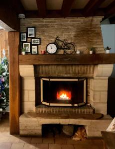 a fireplace with a clock and a bike on it at Eden Cottage in Saint-Gâtien-des-Bois
