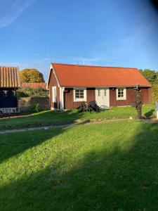 a house with a red roof and a grass yard at Ankiborg Bed and Breakfast in Färjestaden