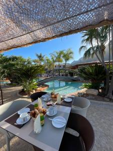 a table with food on it next to a swimming pool at Résidence de Vacances Marina d'Arone in Piana