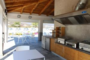 uma cozinha com um fogão, uma mesa e um pátio em hôtel résidence a torra em Vescovato