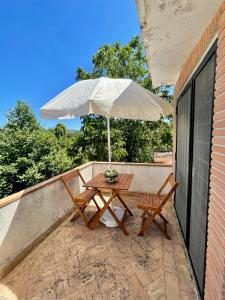 un tavolo e sedie con ombrellone su un patio di Casale Campecora a Barbarano Romano