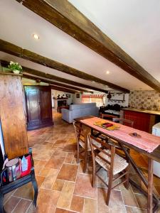 cocina y sala de estar con mesa de madera y sillas en Casale Campecora, en Barbarano Romano