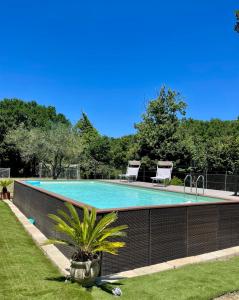 a swimming pool with two chairs in a yard at Casale Campecora in Barbarano Romano