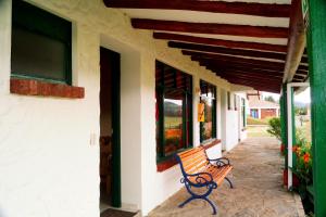 a bench sitting on the side of a building at Hotel Cabañas San Cayetano in Paipa