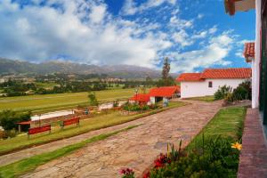 Vistas a una casa con montañas en el fondo en Hotel Cabañas San Cayetano, en Paipa