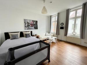 a bedroom with a bed and a living room at City-Apartment nahe Zentrum in Schwerin