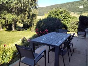 een blauwe tafel en stoelen op een patio bij le héron cendré in Lans-en-Vercors