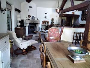 a living room with a table and chairs and a fireplace at le héron cendré in Lans-en-Vercors