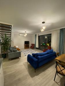 a living room with two blue couches and a television at Sky Villas Hisar in Trabzon