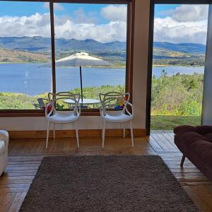 a room with a table and chairs and a large window at Villa Vista in Guatavita