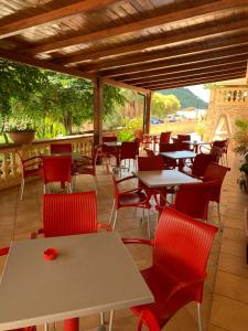 eine Gruppe von Tischen und Stühlen auf einer Terrasse in der Unterkunft Hotel Le Mimose in Acquappesa