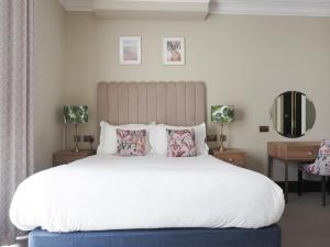 a bedroom with a large white bed with pillows at Hotel Collingwood BW Signature Collection in Bournemouth