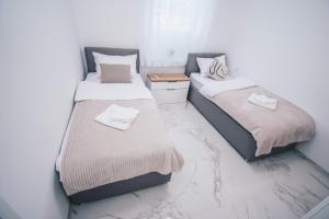 dos camas sentadas una al lado de la otra en una habitación en L Apartment en Maribor