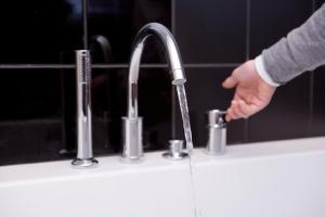 a person is washing their hands under a kitchen faucet at Hotel Restaurant Spa Ivan Vautier in Caen