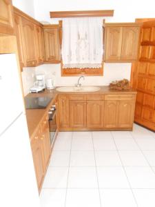 a kitchen with wooden cabinets and a sink at Chrysolithos Kerami Apartments in Khalkíon