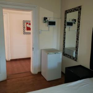 a room with a white refrigerator and a mirror at 13 Maitland Road in King Williamʼs Town +61 photos