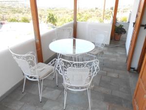 a white table and chairs on a patio at Chrysolithos Kerami Apartments in Khalkíon