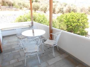 a patio with a table and chairs on a balcony at Chrysolithos Kerami Apartments in Khalkíon