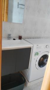 y baño con lavabo y lavadora. en Apartamento vacacional en Orzola Lanzarote, en Orzola
