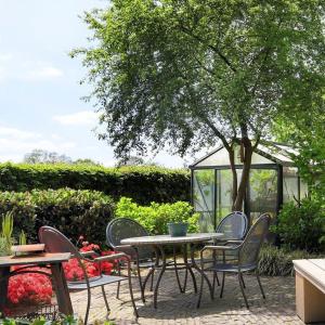 a patio with a table and chairs and a greenhouse at Rheezerstee in Rheeze