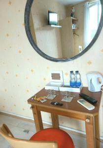 uma secretária com um espelho e uma cadeira vermelha em La Limouxine - Mauzac em Limoux