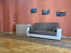 uma sala de estar com um sofá e pinturas na parede em Nonna Maria Sweet Home em Castellana Grotte