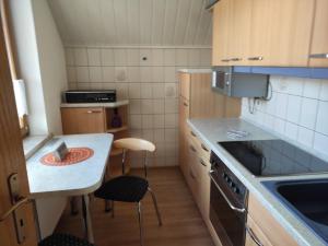 een kleine keuken met een kleine tafel en stoelen bij Ferienwohnung im Werratal in Herrenbreitungen