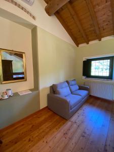 a living room with a blue couch and a window at Agriturismo Val in Costermano