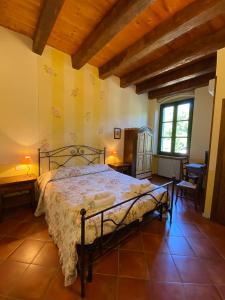 ein Schlafzimmer mit einem Bett, zwei Tischen und einem Fenster in der Unterkunft Agriturismo Val in Costermano sul Garda