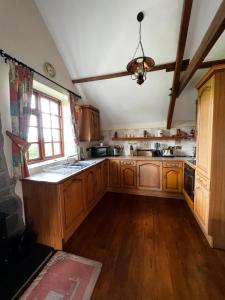 a large kitchen with wooden cabinets and a window at Cwmgwn Farm in Llandovery