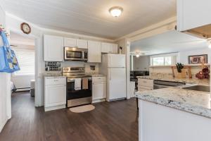 a kitchen with white appliances and wooden floors at Two Brooks Lodge in Bennington
